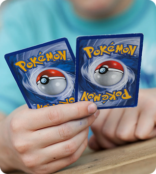 Two hands holding Pokémon cards showing card backs
